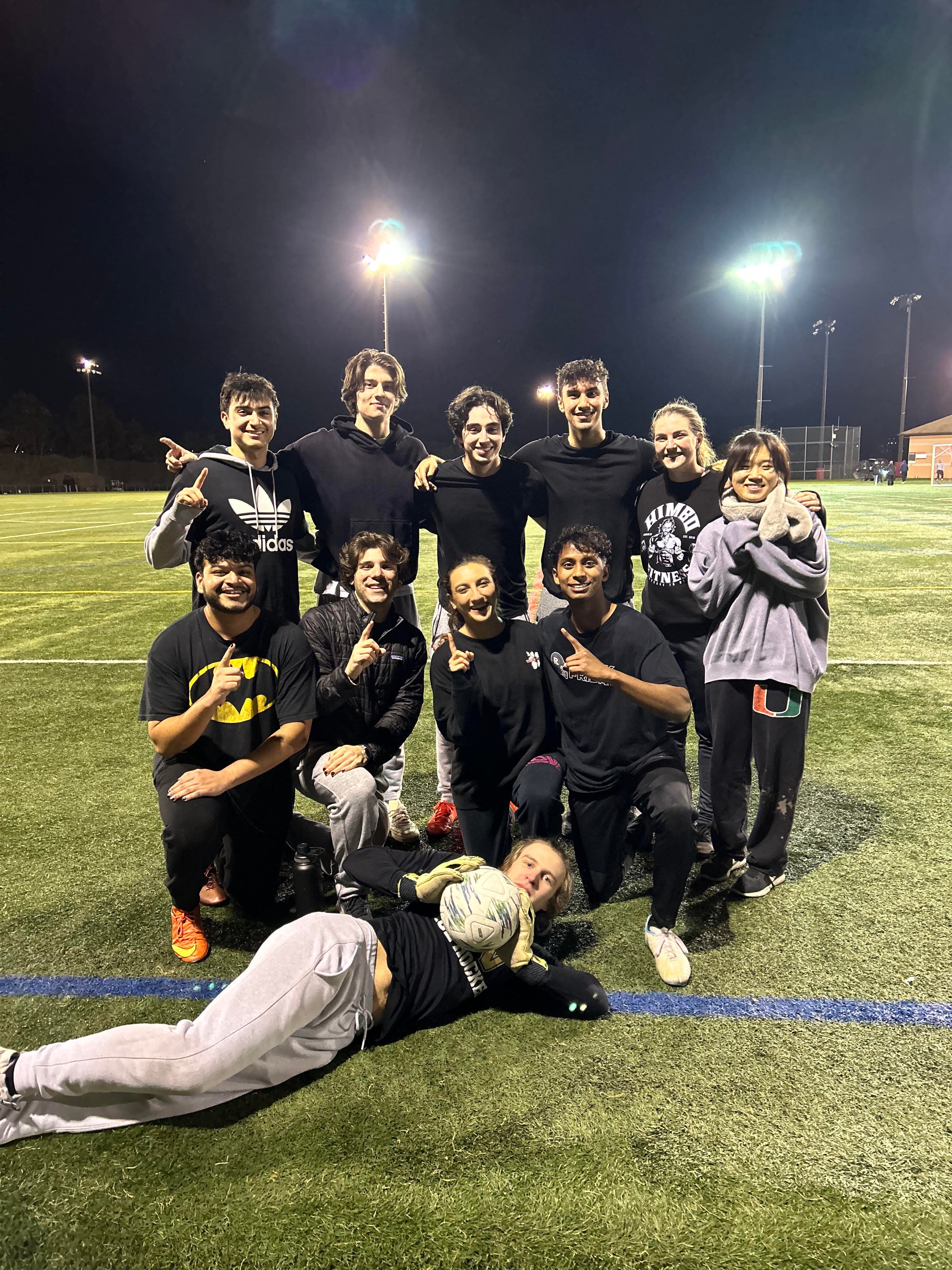 Mateo’s college soccer team posing on a lit field at night, celebrating a league championship
